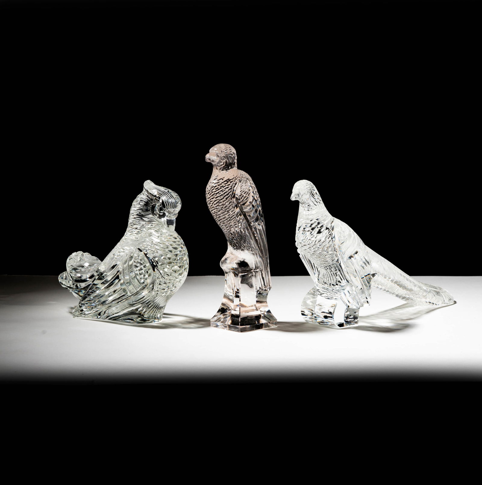 Three Steuben Cut Glass Birds: a perched eagle, a pheasant, and a pigeon; each signed; Eagle: 7 7/8 in. (20 cm.) high; Pheasant: 6 1/4 x 11 x 2 1/2 in. (15.9 x 27.9 x 6.4 cm.); Provenance: The collection of Santa Barbara Steuben co