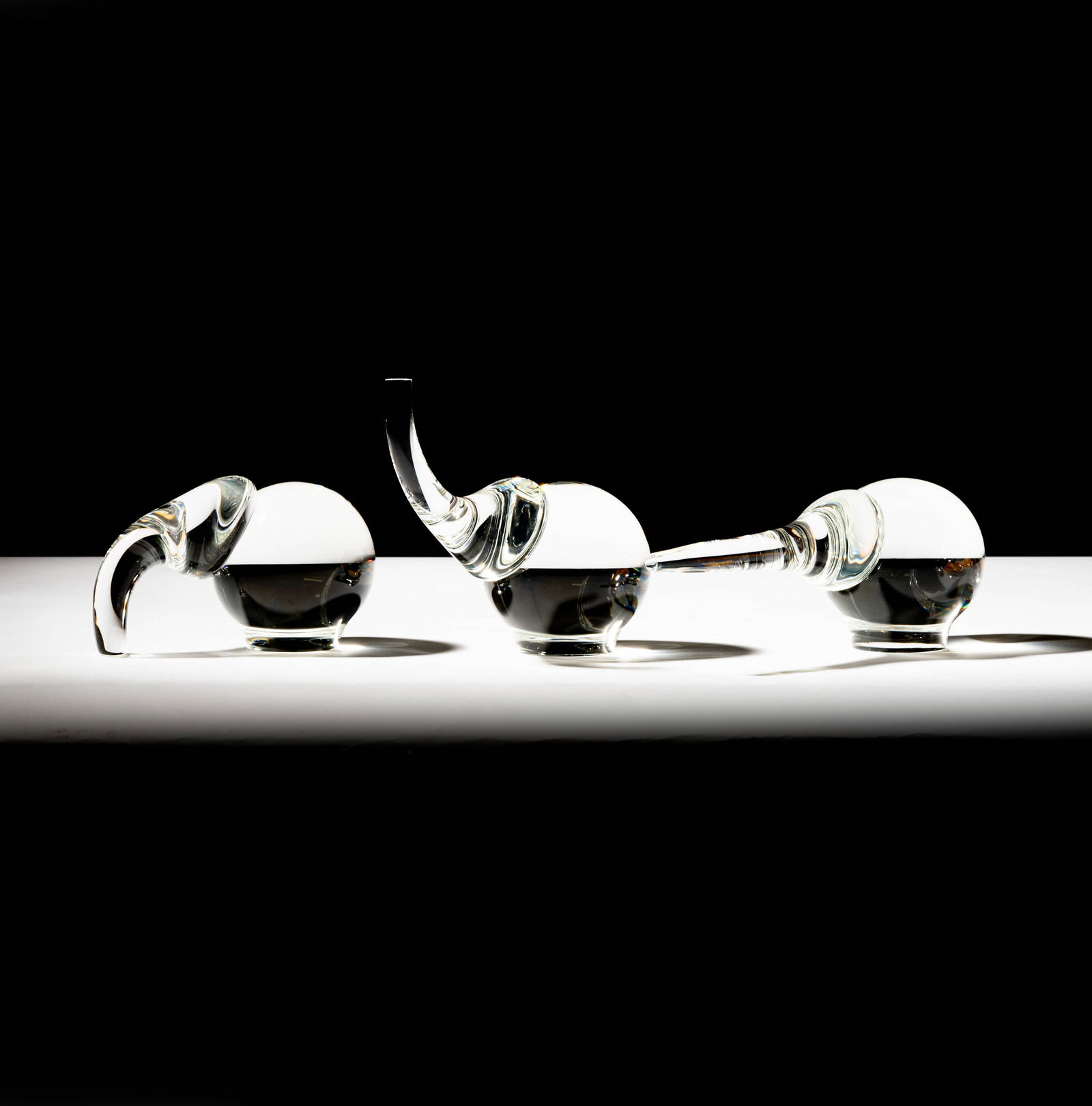 Three Steuben Glass Elephant Sculptures: designed by Paul Schulze; each signed; Tallest: 6 x 6 3/4 x 3 3/4 in. (15.2 x 17.1 x 9.5 cm.); Widest: 3 3/4 x 9 x 3 3/4 in. (9.5 x 22.9 x 9.5 cm.); Provenance: The collection of Santa Barbara Steuben