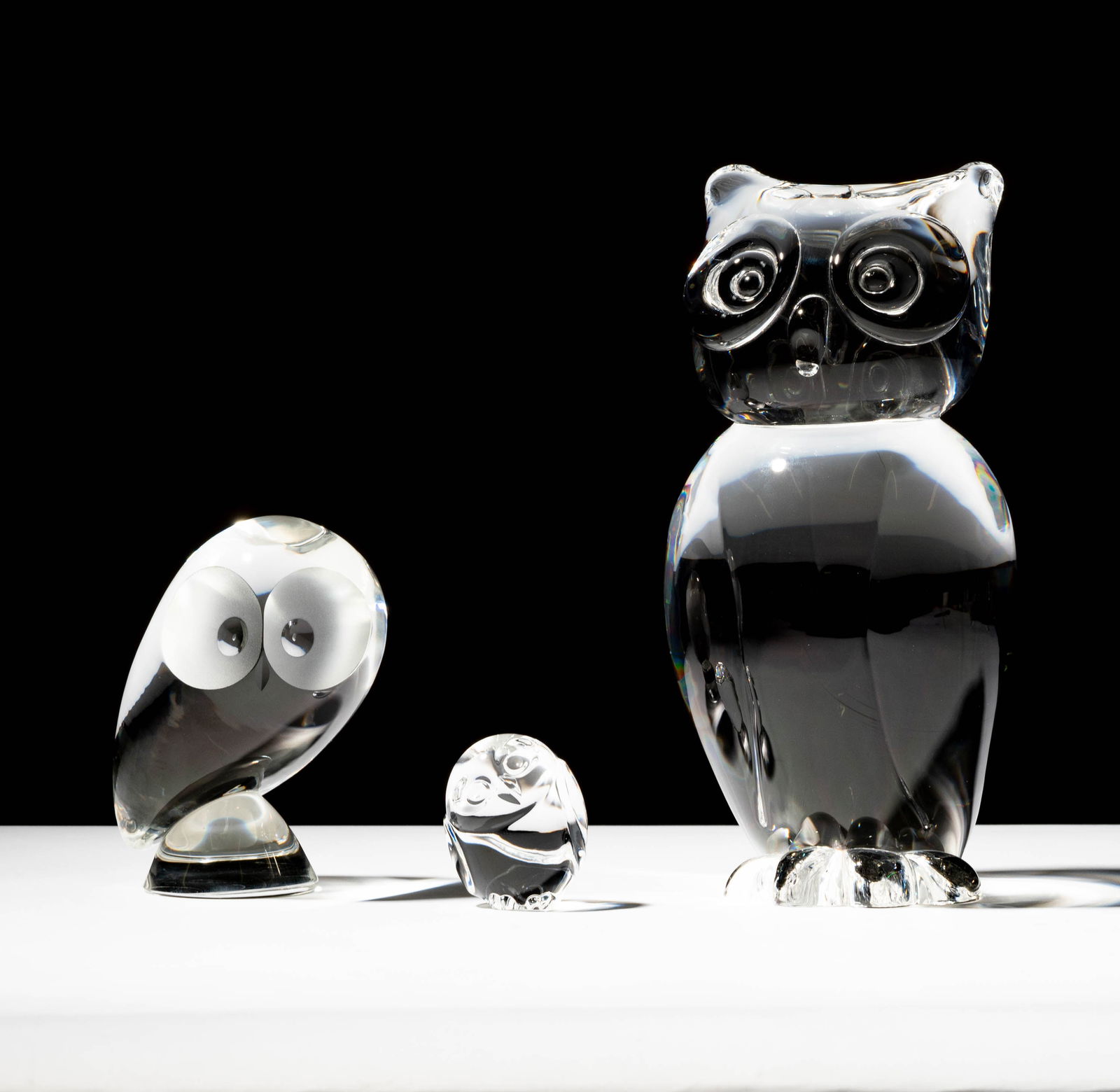 Three Steuben Glass Owl Sculptures: each signed; Ranging from 2 1/2 in. (6.4 cm.) high to 10 x 4 3/4 x 5 in. (25.4 x 12.1 x 12.7 cm.); ; Provenance: The collection of Santa Barbara Steuben collector Joel Kreiner