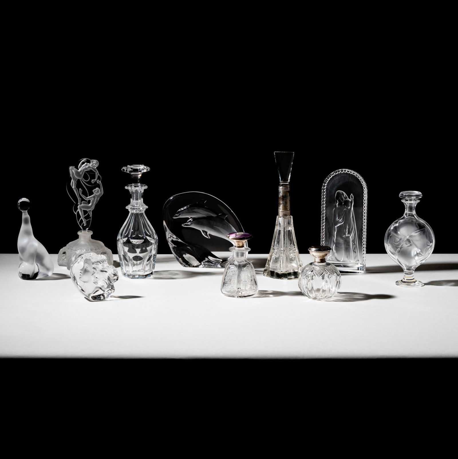 Bob Newhart: A Collection of Crystal Vanity Items: comprising Lalique perfume (7 x 3 1/2 in.), Lalique Madonna and Child (7 1/2 x 3 1/2 in.), Baccarat bottle with stopper (8 1/4 x 3 in.) and other assorted signed and unsigned pieces [10 total] Provena