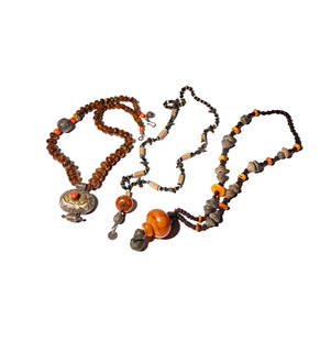 Three Silver-Tone Amber Beaded Necklaces: each necklace comprising various forms of amber; one glass bird accented endless necklace measuring 33 inches long with large old African resin amber pendant measuring 1-1/4 inches in diameter; one