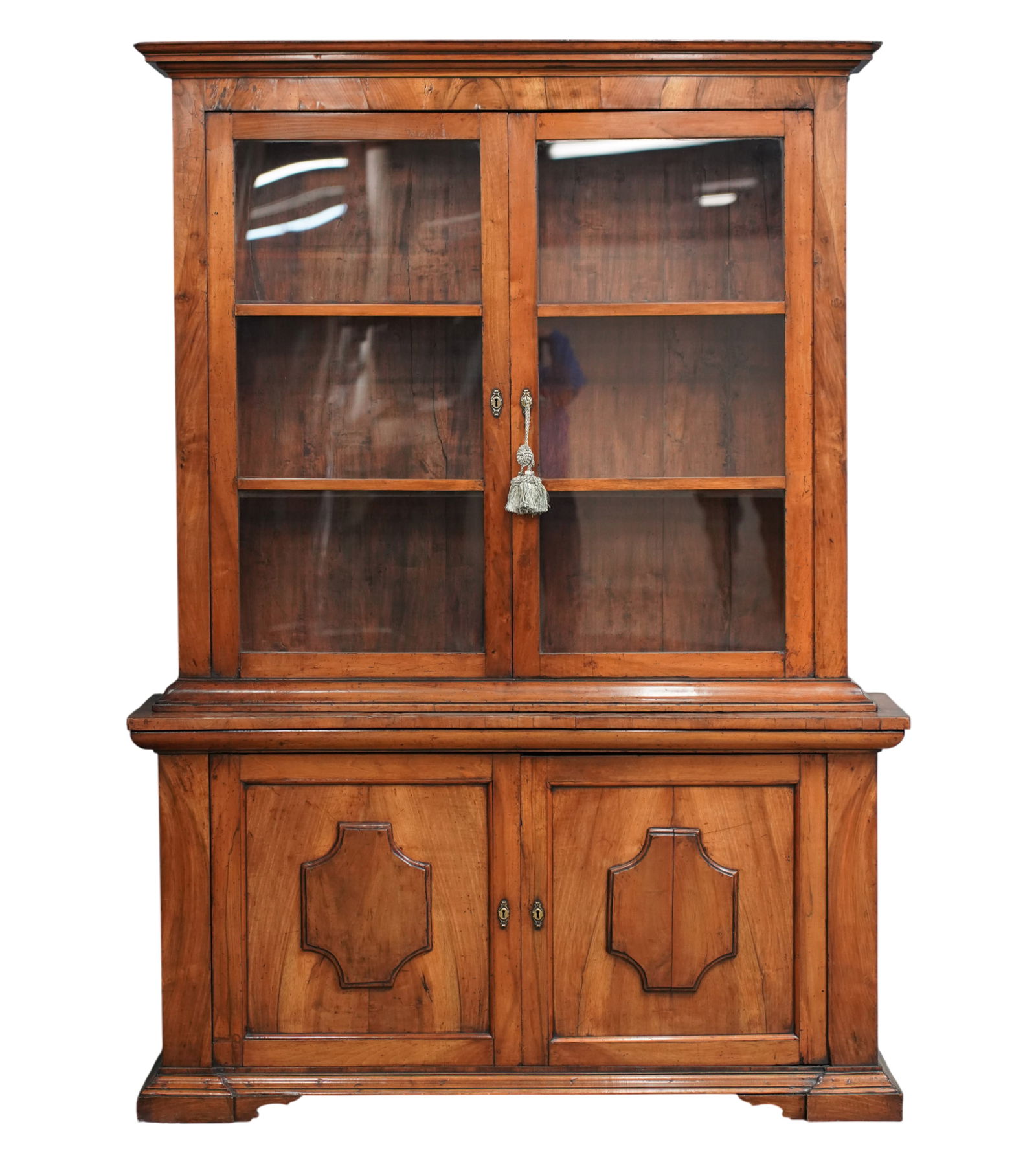 A French Walnut Cabinet: 19th century; in two parts, the upper part with later glass; with key Overall: 91 x 63 1/4 x 16 in. (231.1 x 160.7 x 40.6 cm.)