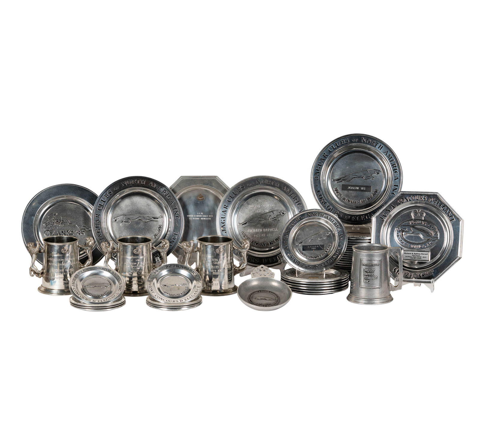 A Group of Jaguar Concours d'Elegance Pewter Plates and Mugs: with engraved insciptions Tankards:: 6 x 7 1/2 x 5 1/4 in. (15.2 x 19.1 x 13.3 cm.) Large plates: 11 in. (27.9 cm.) dia.