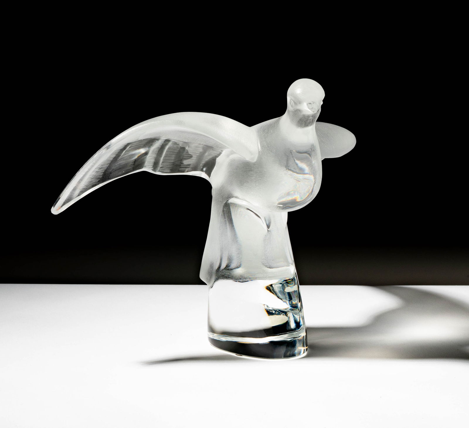 A Lalique Glass Bird Figure: signed "Lalique France" 9 1/4 x 12 1/2 x 10 in. (23.5 x 31.8 x 25.4 cm.)