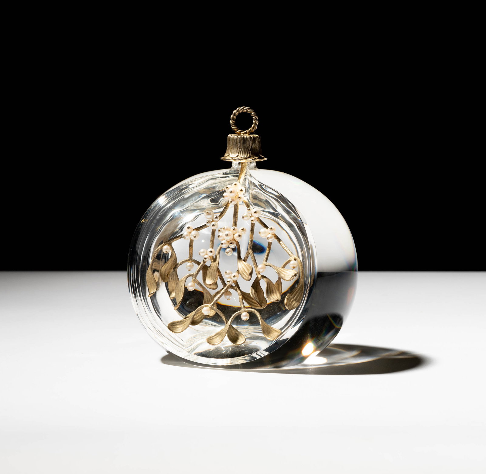 A Steuben Glass, Gilt Sterling, and Cultured Pearl Mistletoe Ornament: designed by Donald Pollard; the glass signed "Steuben", the mistletoe marked "Ster. S"; 6 x 4 3/4 x 3 3/4 in. (15.2 x 12.1 x 9.5 cm.) With original Steuben cardboard box: 6 x 9 1/4 x 6 1/4 in. (15.2 x
