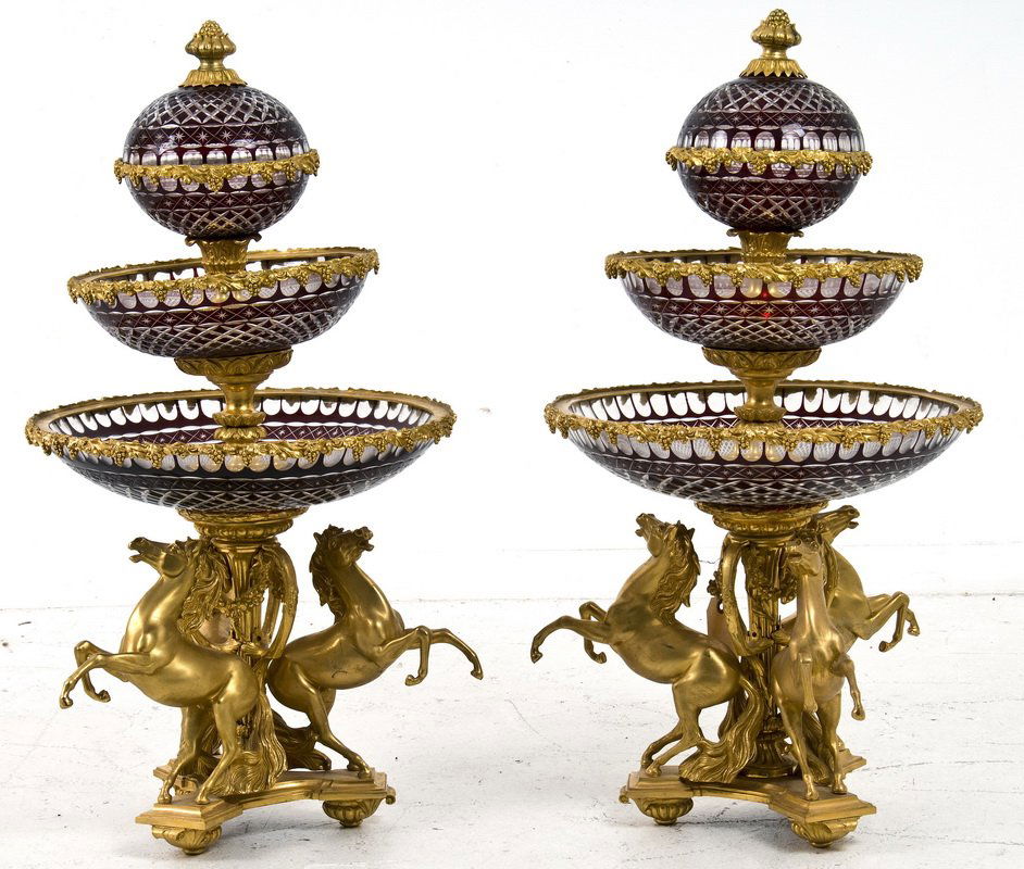 PAIR OF LOUIS XV STYLE BRZ. & COVERED CRYSTAL EPERGNES: each with a covered clear and cranberry crystal bowl above two tiered dishes and a horse-form base 16 inches diameter; 31 inches high