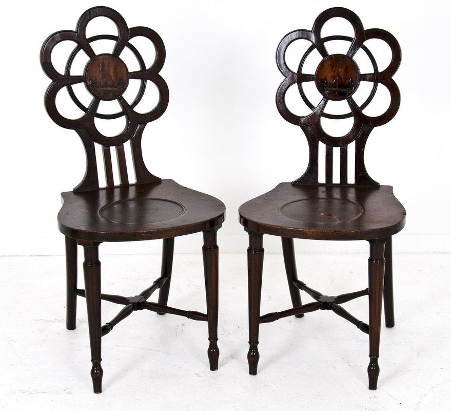 PAIR OF REGENCY PAINTED MAHOGANY HALL CHAIRS: each with pierced foliate back centering a circular reserve painted with a crest over a dished compass seat, on cylindrical legs joined by X-form stretchers Provenance: Estate of David Copley, La Joll