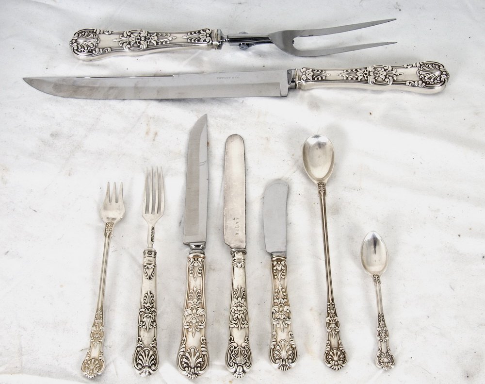 TIFFANY & CO. STERLING PARTIAL FLATWARE SERVICE: Kings pattern comprising of 57 pieces including twelve steak knives, twelve butter spreaders, twelve cocktail forks, twelve ice tea spoons, seven demitasse spoons, and a two-piece carving set; also wi