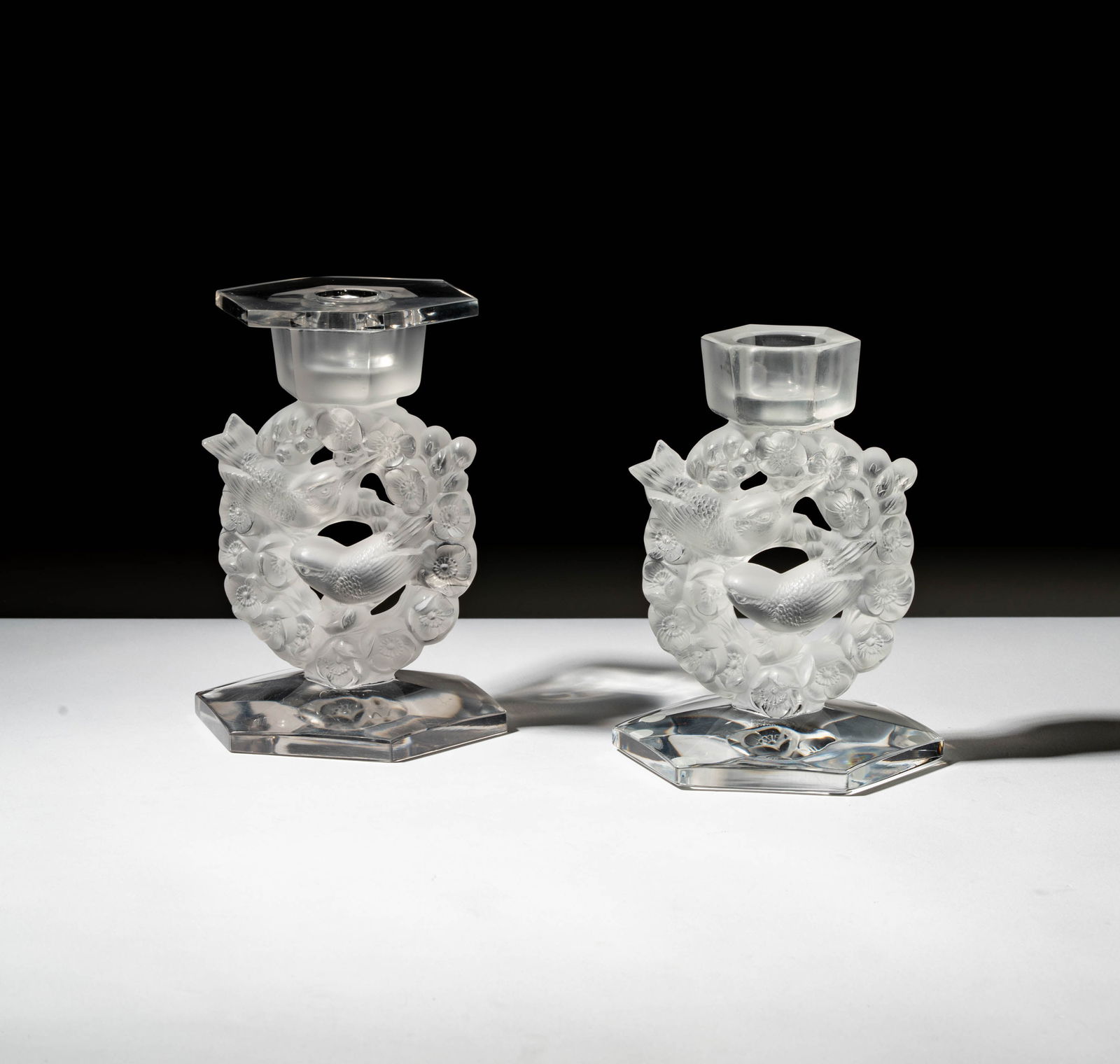 A Pair of Lalique Figural Bird Candlesticks: signed, one candlestick missing hexagonal bobeche, 6 3/4 x 5 x 4 1/2 in. (17.1 x 12.7 x 11.4 cm.),