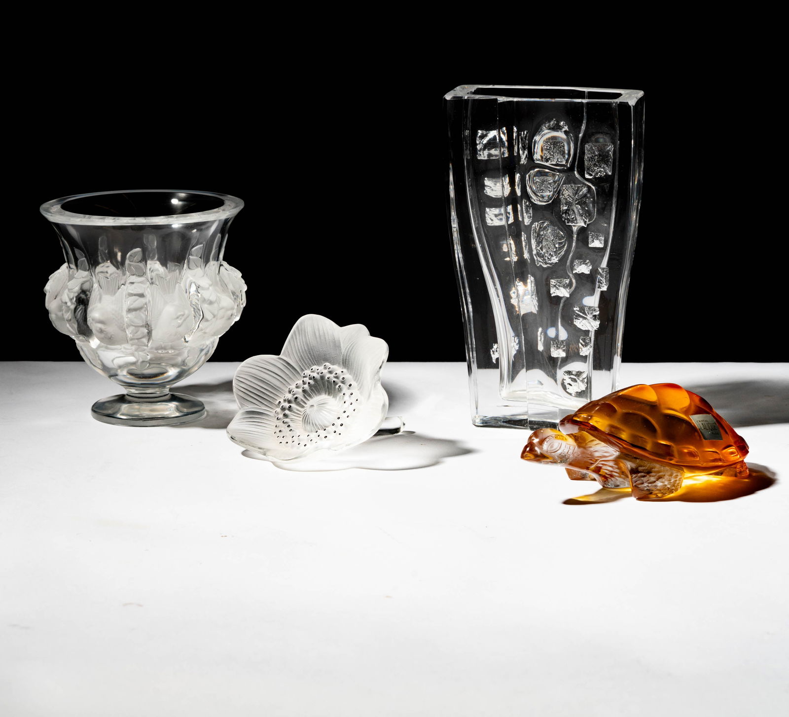 Group of Lalique and Daum Glass: comprising a Lalique "Dampierre" vase (4 3/4 in. high), a Lalique anemone flower (4 in. dia.), a Lalique amber-colored turtle figure (5 1/2 in. wide), and a Daum rectangular vase (7