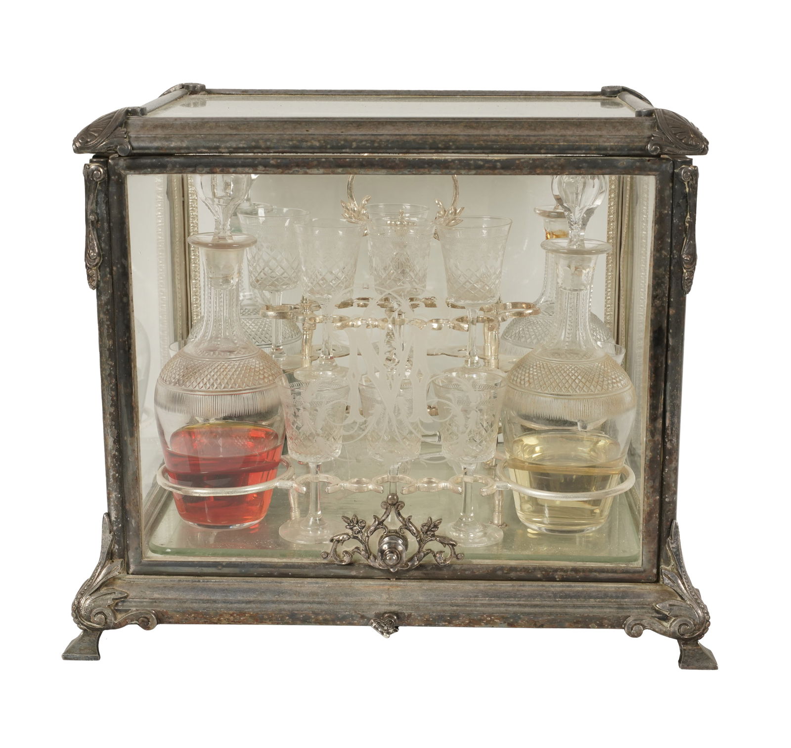 A French Glass and Silvered Metal Tantalus: the front panel etched with the initial "M"; the interior fitted with two decanters and eight liqueur glasses; with key, 11 x 13 1/2 x 11 in. (27.9 x 34.3 x 27.9 cm.)