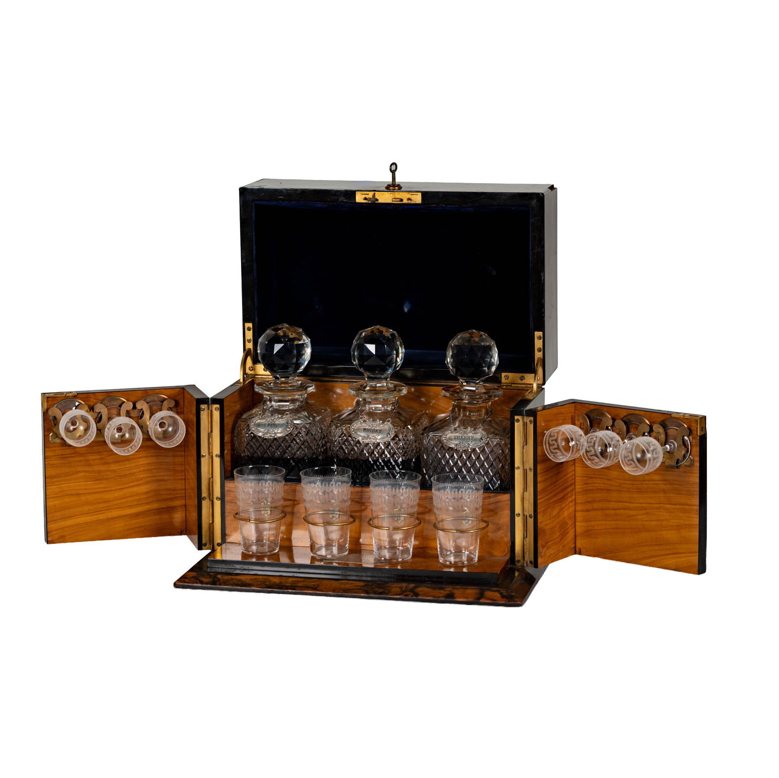 A Victorian Coromandel Tantalus: England, c. 1889, with three cut glass decanters and ten glasses, with presentation plaque engraved "Presented to Arturo Gispert by Members of the Curlew Rowing Club on his Marriage 26th Jany. 1889",