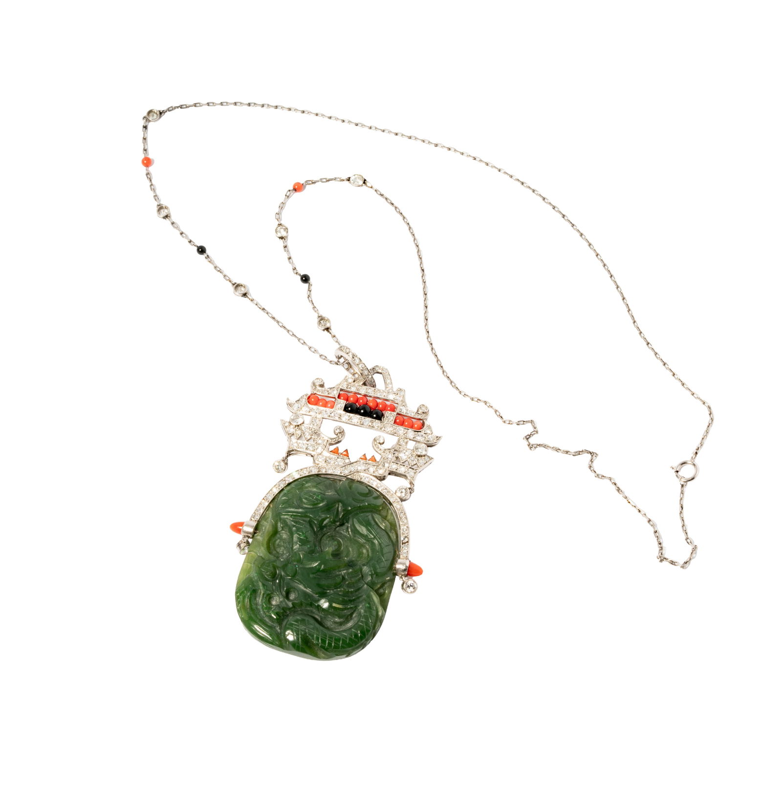 Art Deco, 18 Karat White Gold, Platinum, Diamond, Coral and Jade Necklace: Comprising a platinum pendant on an 18 karatwhite gold chain; the pagoda-shaped pendant features one oval carved nephrite jade measuring approximately 42.00 x 42.00 x 6.00 mm; set with coral and onyx