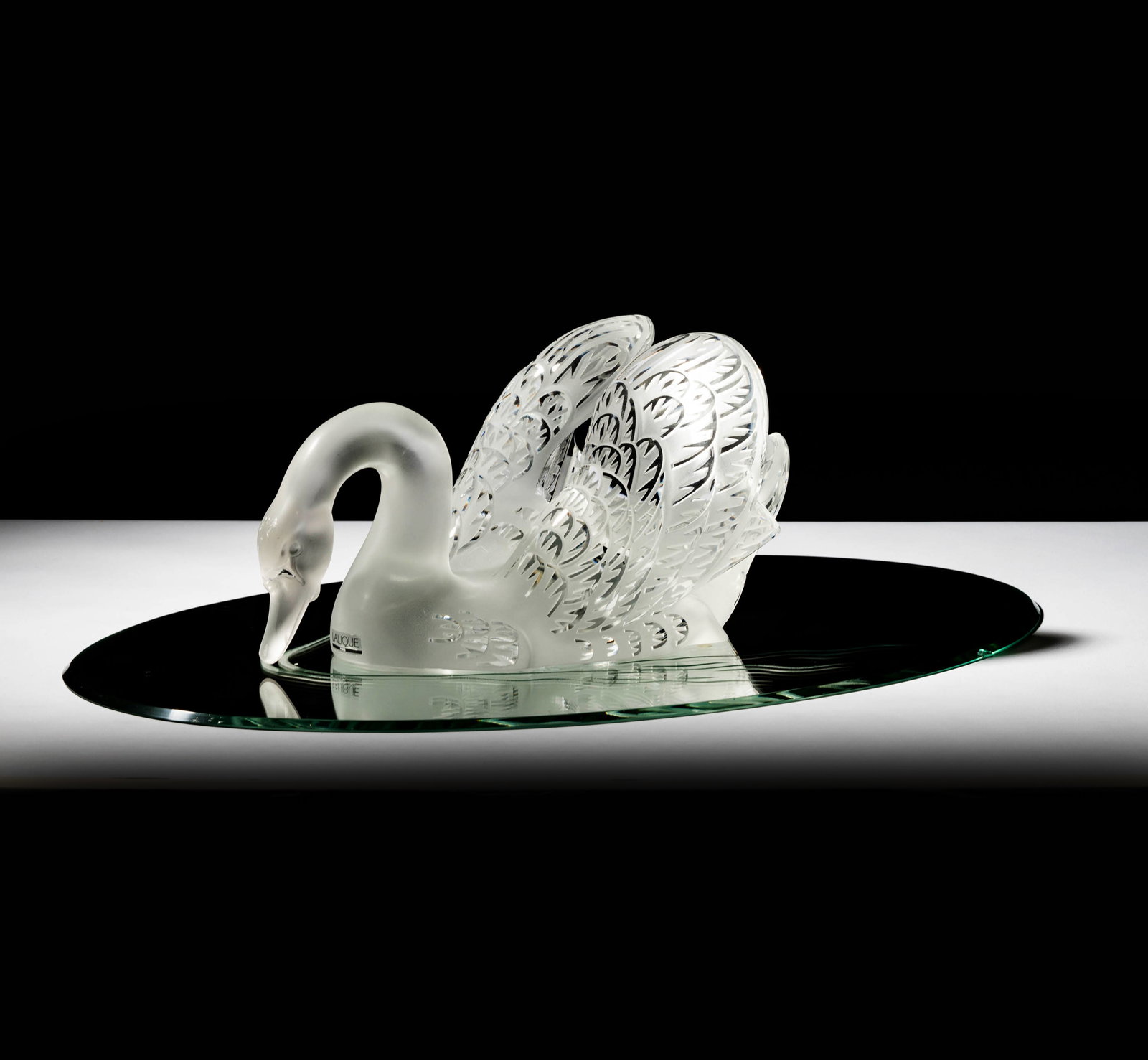 Lalique Miroir Cygnes Glass Centerpiece: comprising one swan figure, 7 x 14 x 8 in., and an oval etched mirror glass plateau, 24 x 15 1/2 in.