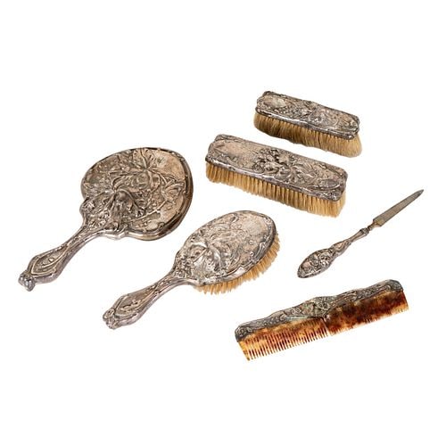 Repousse Silver Dresser Set: comprising three brushes, a mirror, a file, and a comb, mirror: 9 3/4 x 5 x 3/4 in., comb: 7 3/4in.