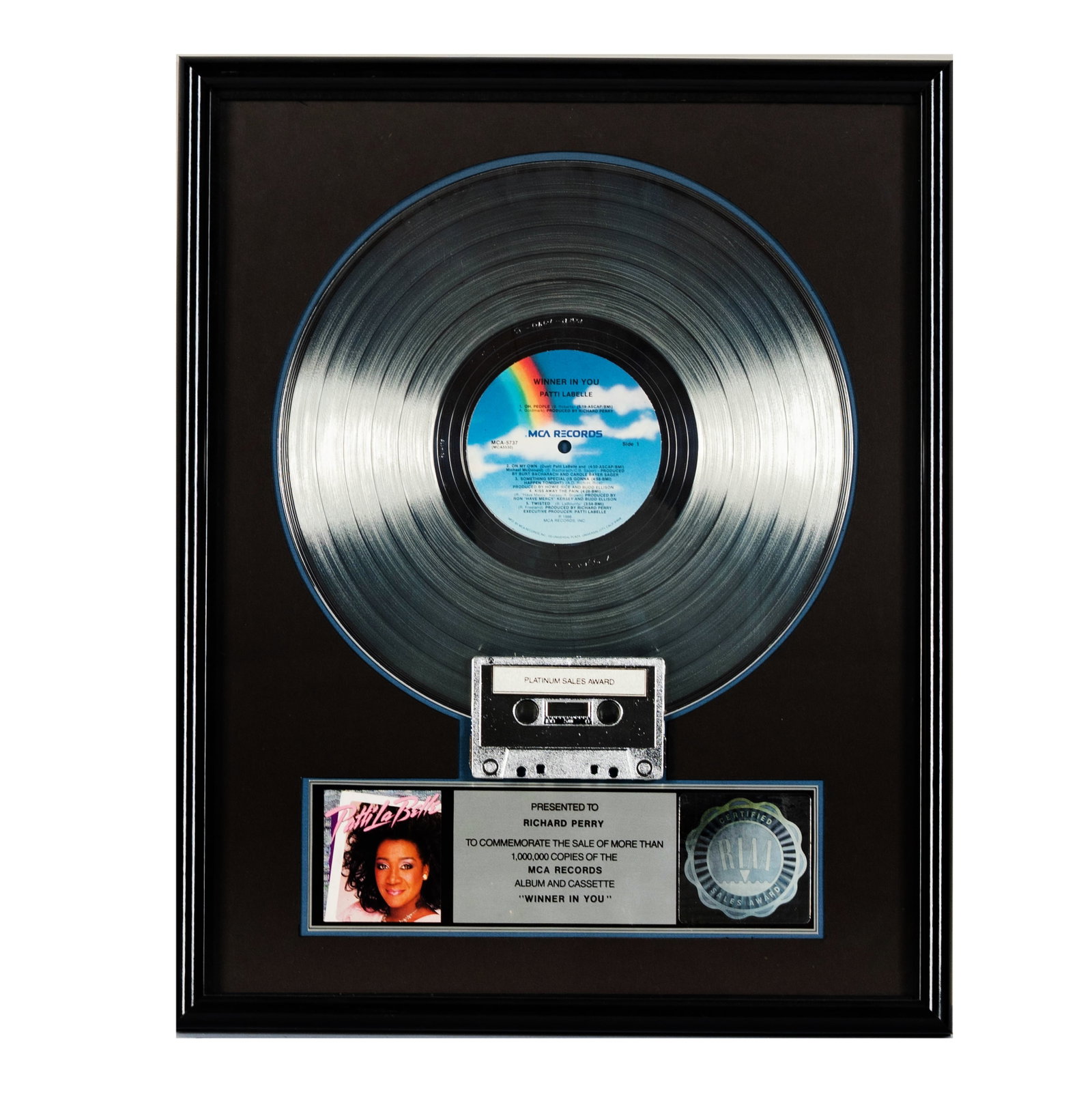 Richard Perry's Platinum Record Patti LaBelle 'Winner In You': This framed award commemorates the sale of over 1,000,000 copies of Patti LaBelle's album and cassette 'Winner In You'. It features a platinum record, a cassette tape labeled 'Platinum Sales Award', a