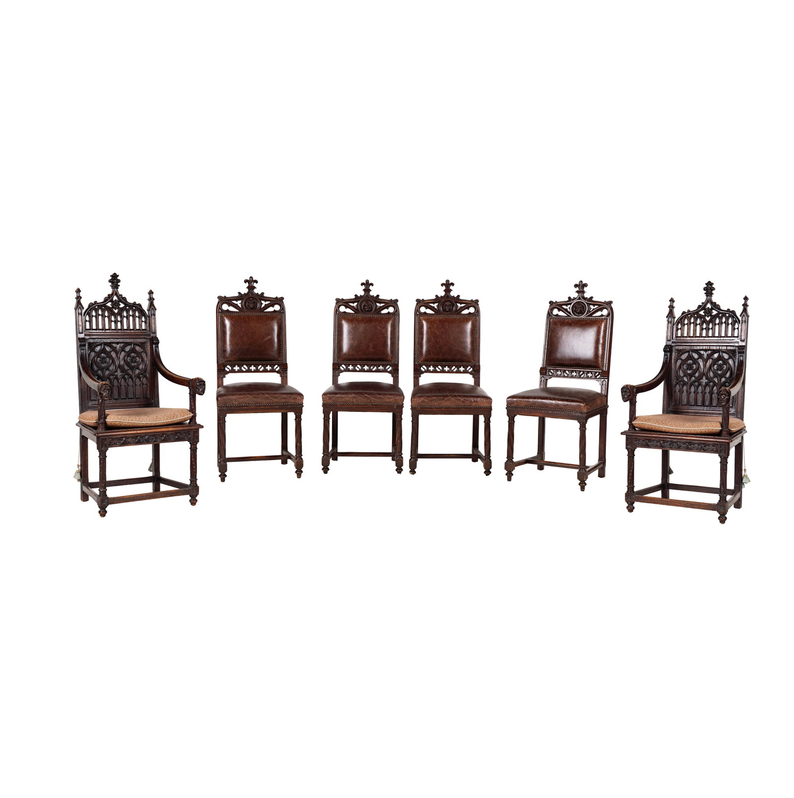 A Set of Six Gothic Carved Oak Dining Chairs: comprising two armchairs and four side chairs, each with face motif