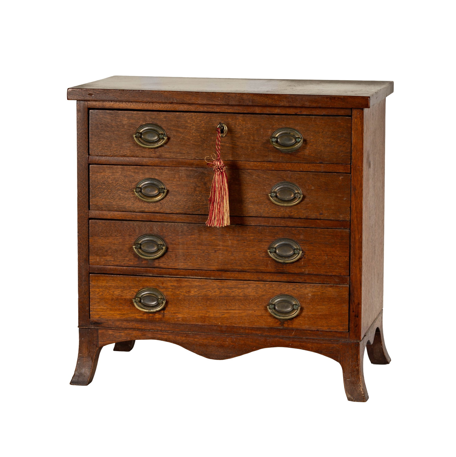 A Diminutive Sheraton Style Chest of Drawers: Mahogany, with Sheraton style brass hardware, top drawer with lock and key, 19 h x 19 w x 11 1/2 ins d.