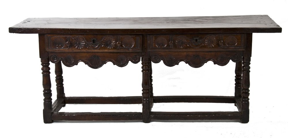 SPANISH BAROQUE CARVED WALNUT SIDEBOARD: the rectangular top above two frieze drawers, scalloped apron, turned supports, and box stretcher 81 1/2 inches long; 23 1/2 inches wide; 31 inches high