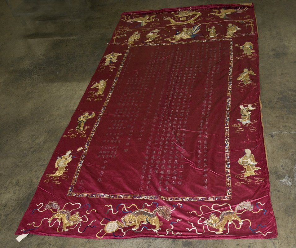 CHINESE SILK PANEL: the calligraphy-imprinted cloth with borders of gold and colored thread motifs of dragons and lions Provenance: Estate of David Copley, La Jolla 11'6" x 5'9"