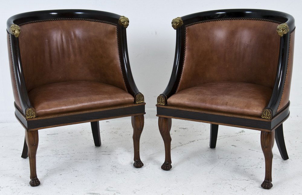 PAIR OF ART DECO EBONIZED & MAHOGANY BARREL CHAIRS: each with leather upholstery and brass lion's head terminals Provenance: JF Chen, Los Angeles