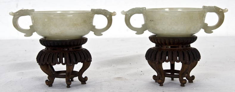 PAIR OF CHINESE CARVED JADE LIBATION CUPS: each on a carved hardwood stand Provenance: Estate of David Copley, La Jolla 5 inches long; 1 1/2 inches high