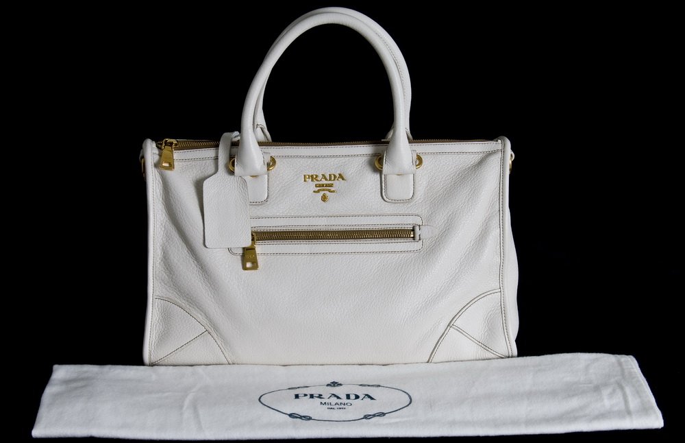PRADA DEERSKIN LEATHER SMALL TOTE: cream color; gold tone hardware and metal logo lettering; jacquard logo lining; metal feet and detachable shoulder strap; zips at top 13 inches wide; 7 inches deep; 9 inches high
