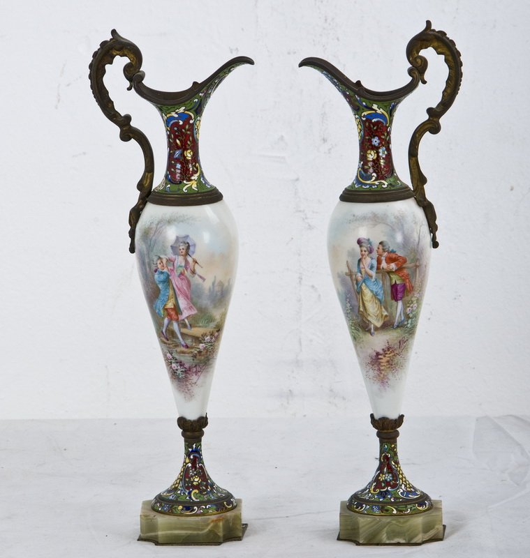 PAIR OF FRENCH ENAMEL & PORCELAIN EWERS: each with gilt metal handles and a champleve enameled neck and foot with a porcelain body of figures in a landscape, on an onyx plinth 16 inches high