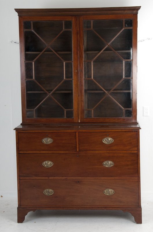 GEORGIAN MAHOGANY BUREAU BOOKCASE: the upper cabinet with a molded cornice and a pair of mullioned glazed doors resting on a bureau with two short and two long drawers 49 inches wide; 23 inches deep; 83 inches high