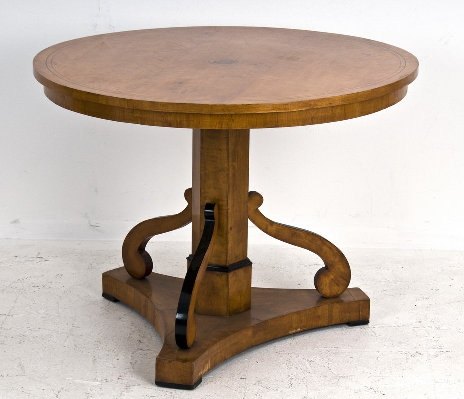 CHERRY & EBONIZED BIEDERMEIER SIDE TABLE: the circular top having an inlaid sword and dove trophy and thin inlay along the perimeter; on a hexagonal shaft and ebonized shaped scroll supports connecting to a tripartite base 39 1/2 inches diame