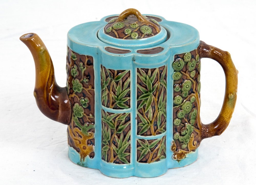 MINTON MAJOLICA "THREE FRIENDS" TEAPOT: circa 1875 the teapot molded in the form of bamboo, with prunes, bamboo, and flowering branches in green and tan glaze on a blue ground with branch form spout and handle, the domed cove with a floweri