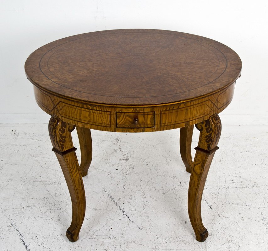 BIEDERMEIER SATINWOOD OCCASIONAL TABLE: the round top over an inlaid frieze with four small drawers on four cabriole legs with decorative inlay at the knees 37 1/4 inches diameter; 27 1/2 inches high