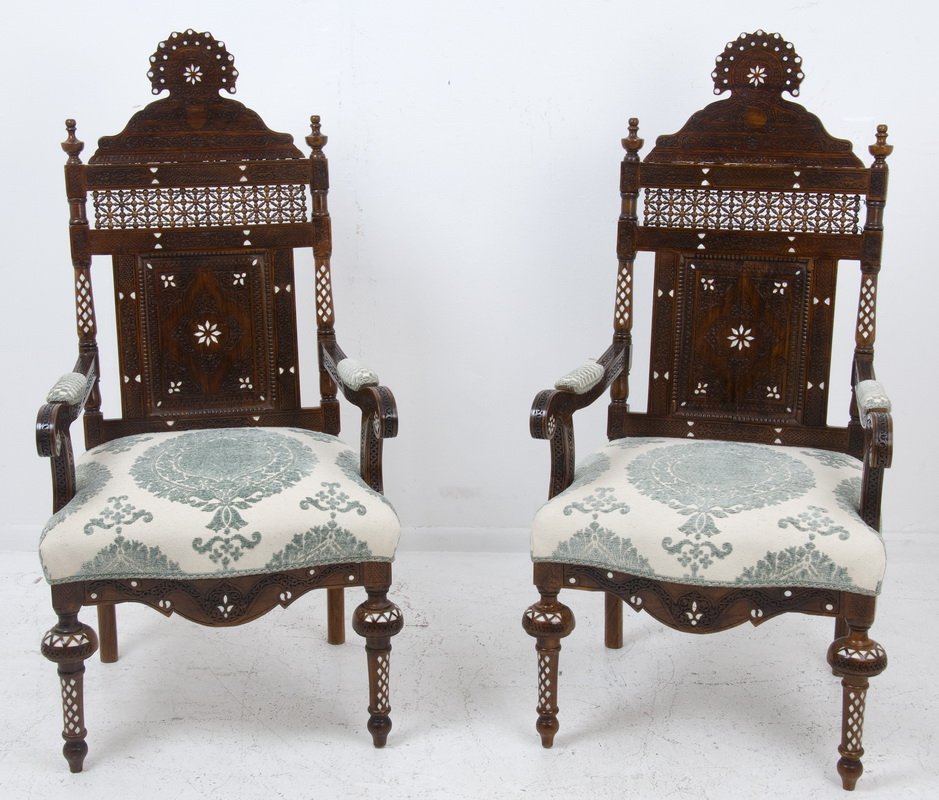PAIR OF DAMASCUS INLAID HALL CHAIRS: the carved and mother-of-pearl inlaid frame having a straight back with a shaped surmount and a beaded and reticulated crest rail; having a blue and cream upholstered seat and padded scrolling arms, a