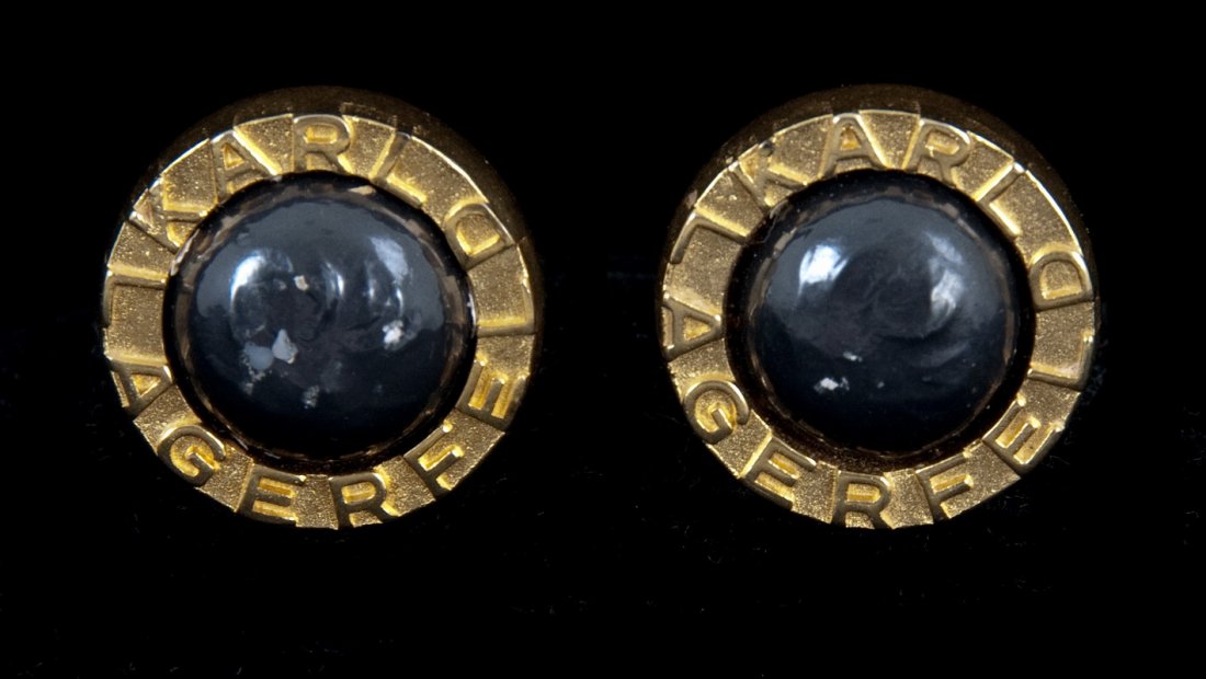 KARL LAGERFELD GOLDTONE BUTTON EARRINGS: Circular Karl Lagerfeld logo surrounding a black stone Diameter: 1 inch