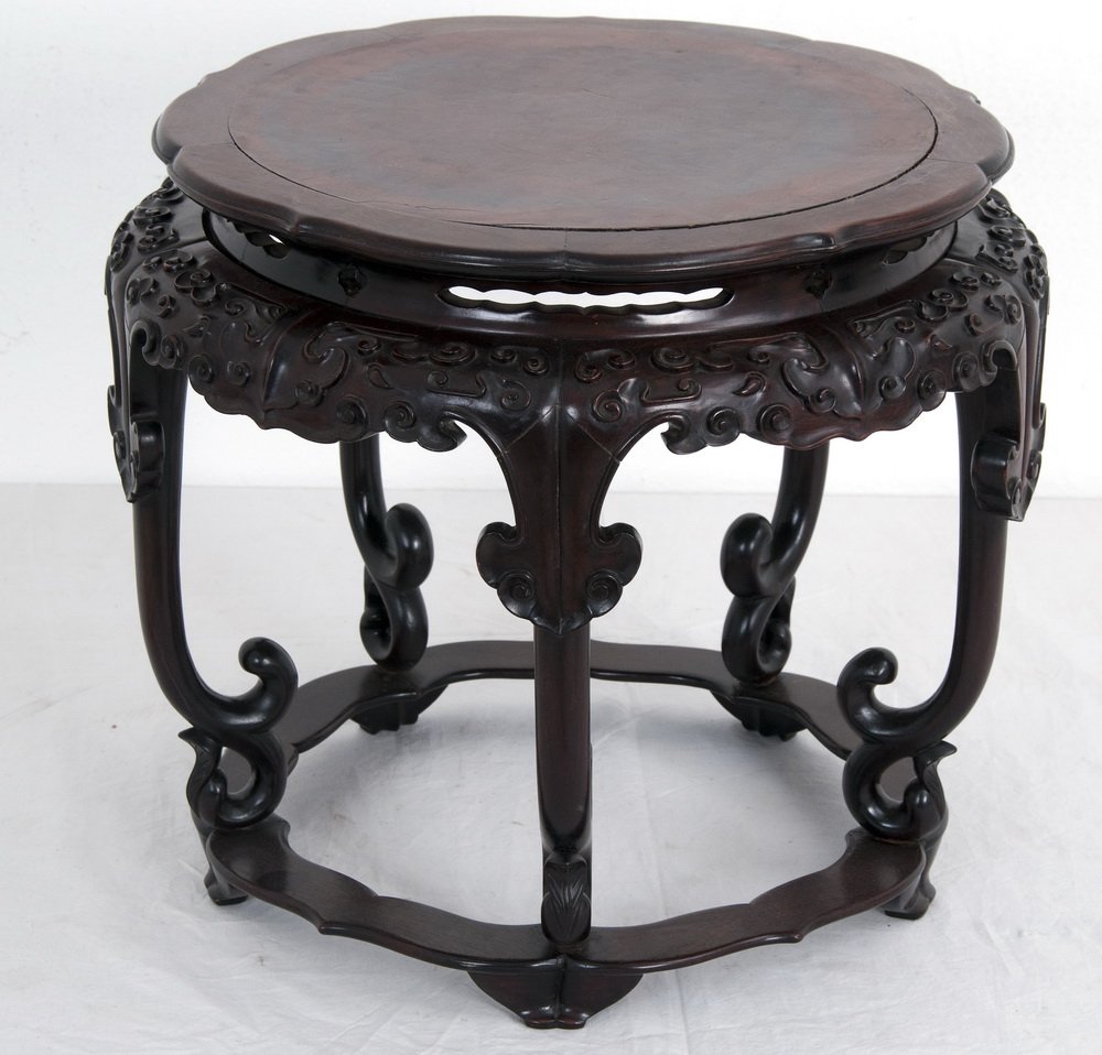 CHINESE CARVED ROSEWOOD STOOL: the lotus form round seat above a stylized case 16 inches diameter; 13 1/4 inches high
