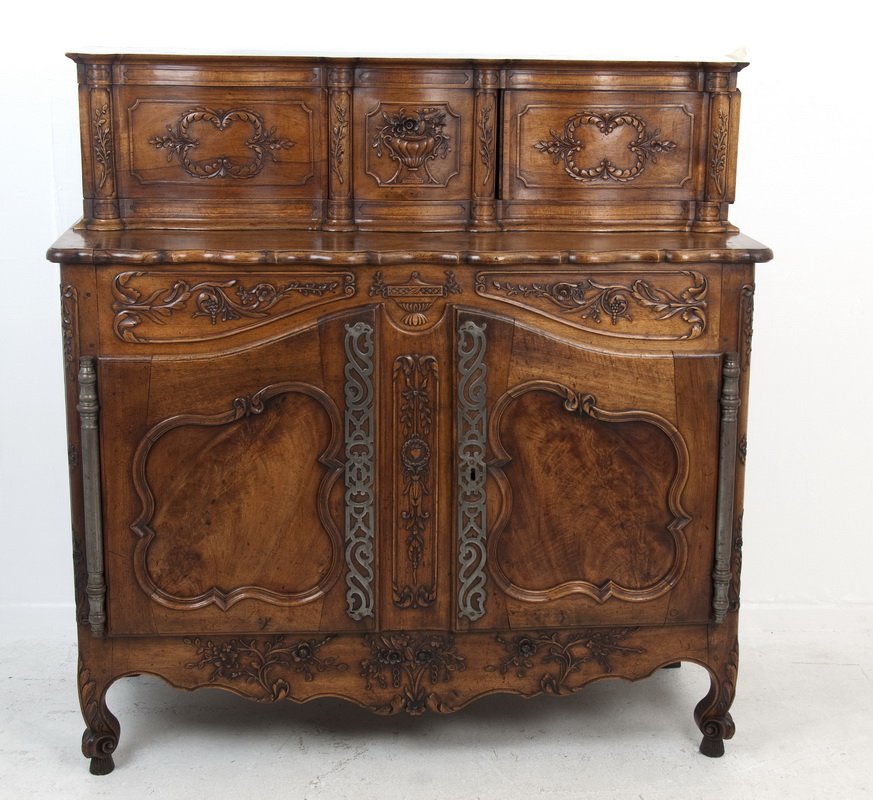 FRENCH PROVINCIAL TWO-PART BUFFET: the carved floral and urn motif buffet comprising a case of two cartouche-paneled doors, bronze hardware, and a scalloped apron all surmounted by a recessed cabinet of two paneled sliding doors flanke