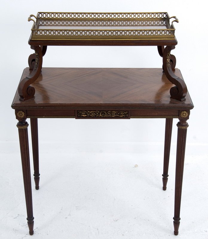 LINKE ORMOLU-MOUNTED TIERED DESSERTE: the upper tier with glass and bronze gallery rim tray insert on scrolling supports above a lower tier and four tapering round fluted legs 28 inches wide; 17 inches deep; 36 1/2 inches high