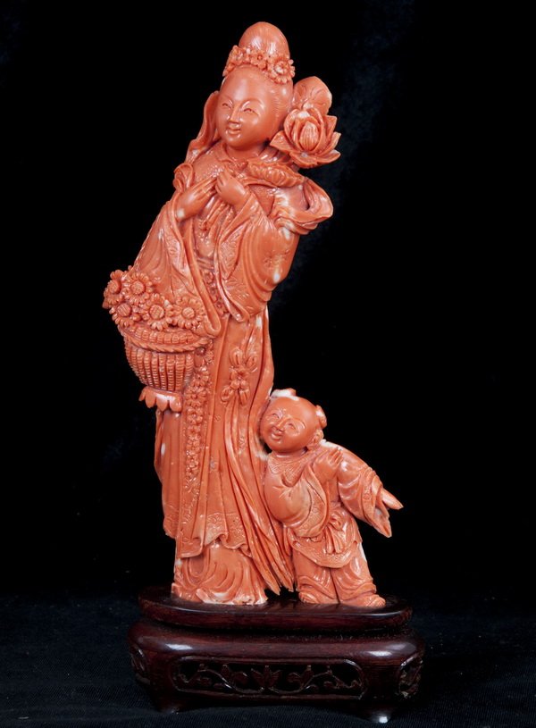 CHINESE CARVED CORAL QUAN YIN WITH ATTENDANT: Condition: with small loss to attendant's hand and a few negligible losses to robes 4 3/4 inches wide; 8 1/2 inches high; 527 grams without base