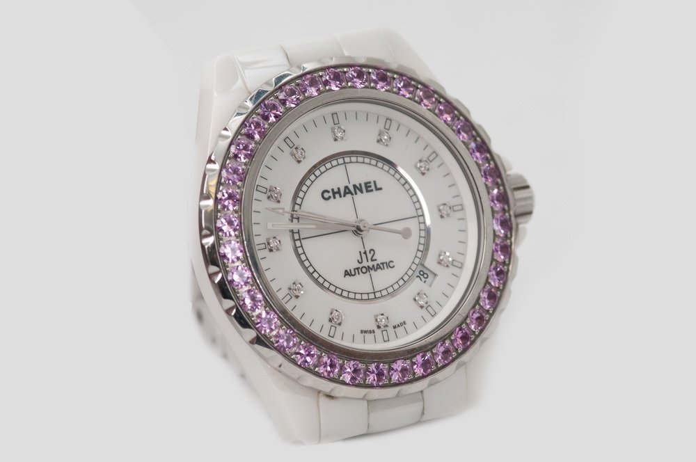 CHANEL J12 WHITE CERAMIC WATCH: White ceramic and stainless steel watch and bracelet. Pave set pink sapphire bezel. Case measures 42mm in diameter