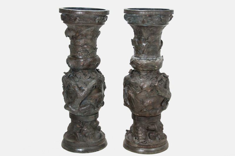 PAIR OF MONUMENTAL PATINATED BRONZE JAPANESE URNS: the upper and middle sections of each body decorated with cranes, birds, branches and leaves, the lower sectionals decorated with dragon turtles 53 3/4 inches high