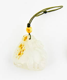 A white and russet jade pendant: carved with a monkey embracing an oversized peach sitting on a spray with leaves and further smaller peaches H. 33mm Provenance: From the Leo Walker Tattersfield Collection of Chinese Jades