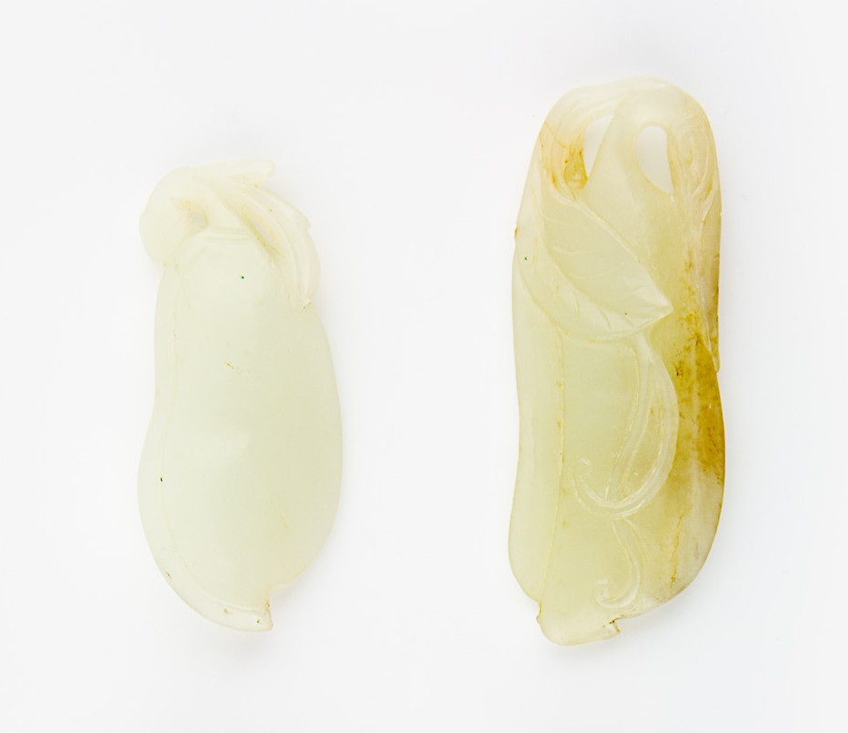 Two celadon jade pendants: carved with fruits issuing from a leafy spray The largest, H. 75mm Provenance: From the Leo Walker Tattersfield Collection of Chinese Jades