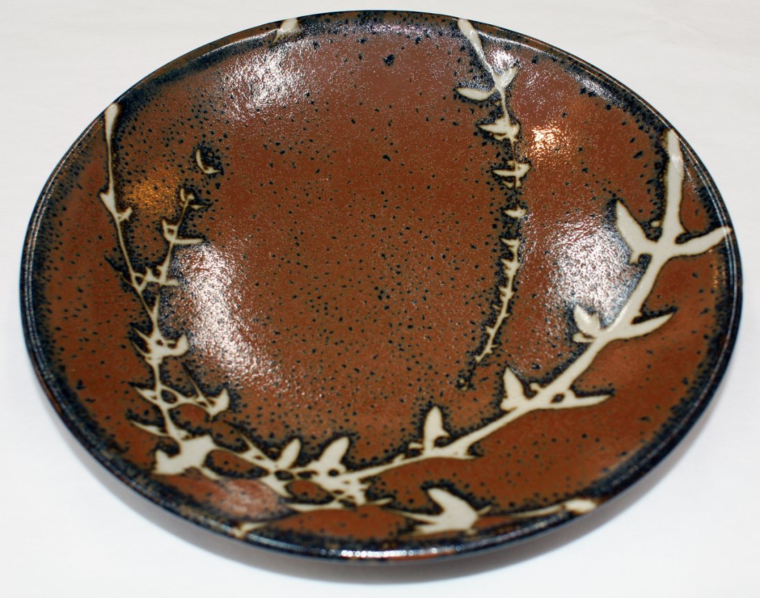 Japanese Mashiko pottery stoneware plate: with poured tenmoku and nuka glaze depicting a blossoming tree over a rich brown ground glaze together with another Mashiko plate with wax resist decoration. D.390mm