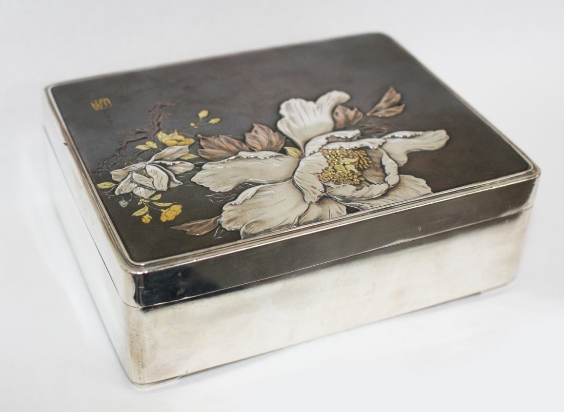 Japanese silver box: Meiji period (1868-1912), with raised and inlaid in gold and copper decoration of peony and prunus branches, signed and marked Jungin. W. 135mm