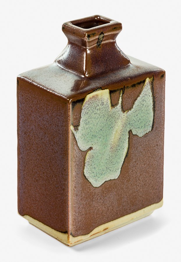 Shoji Hamada: Rectangular stoneware bottle vase, press moulded, covered in a kaki glaze with poured jun glaze shaped panels to the front and back, with signed wood box. H. 160mm Provenance: Gary Winther Collection