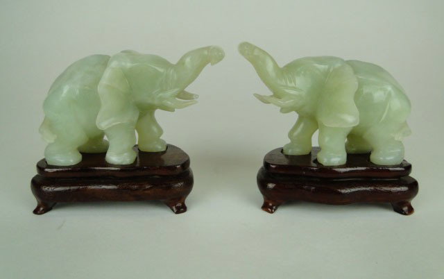PAIR OF CARVED JADE ELEPHANTS ON STANDS: PAIR OF CARVED JADE ELEPHANTS ON STANDS Each Approximately 4 Inches Long Both with Trunks Up Good Condition one Tusk Chips, SHIPPING U.S. TO BE $20 PLUS INS
