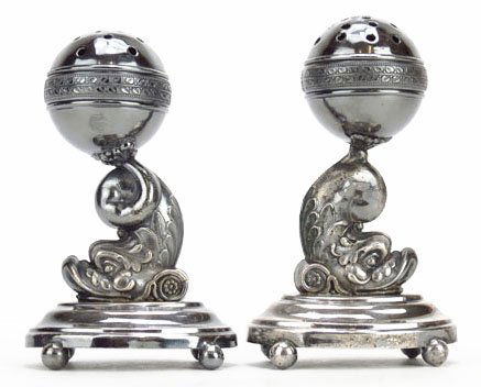 PAIR OF VINTAGE ORNATE SUGAR SHAKERS: PAIR OF VINTAGE ORNATE SUGAR SHAKERS Measures 5.25" tall silver plated with dolphin motif. Each stands on 4 ball feet circa mid 20th century. Good condition. We will not ship this item. We will happil