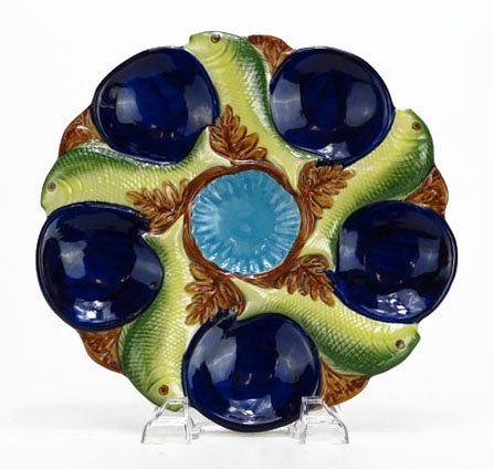 ANTIQUE MAJOLICA OYSTER PLATE: ANTIQUE MAJOLICA OYSTER PLATE Measures 9" diameter with fish motif. Spot for 5 oysters marked to base early 20th century probably Portugal. We will happily recommend a list of outside vendors upon req