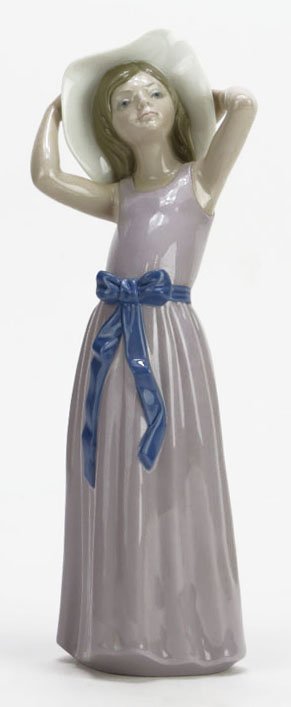 Lladro Figure of a Girl Trying On A Straw Hat No. A17: Lladro Figure of a Girl Trying On A Straw Hat No. A17 Retired 1998. Measures 10-1/4" Tall by 4" Wide. Very Good Condition. Estimate $80-$120