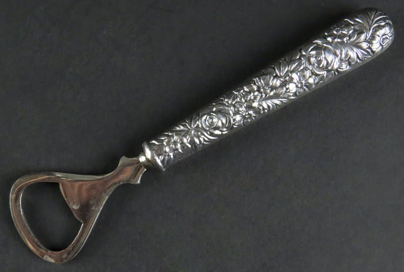 S. Kirk and Sons Steiff Bottle Opener with Sterling: S. Kirk and Sons Steiff Bottle Opener with Sterling Silver Repousee Handle. Good Condition. Measures 6-3/8 Inches Long. Gross Weighs 1.81 Troy Ounces. Shipping $20.00